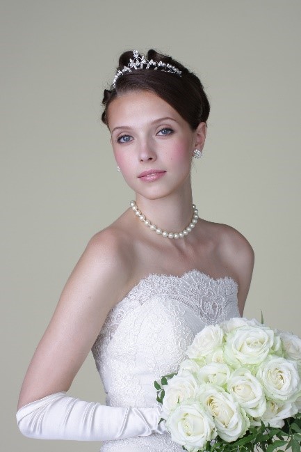 A person in a wedding dress holding a bouquet of flowersDescription automatically generated